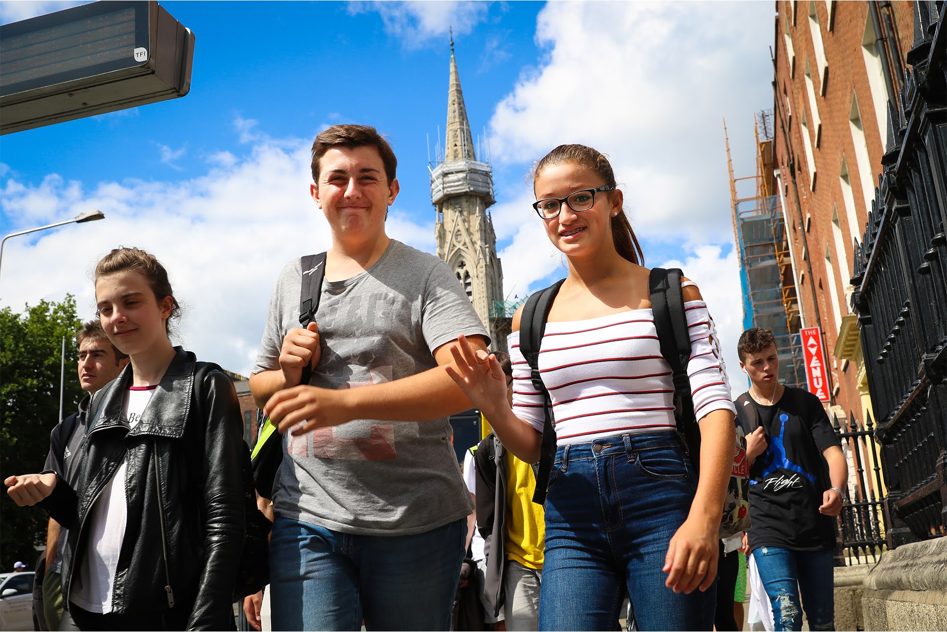 Junior summer camp students walking through Dublin city streets past a historic church spire