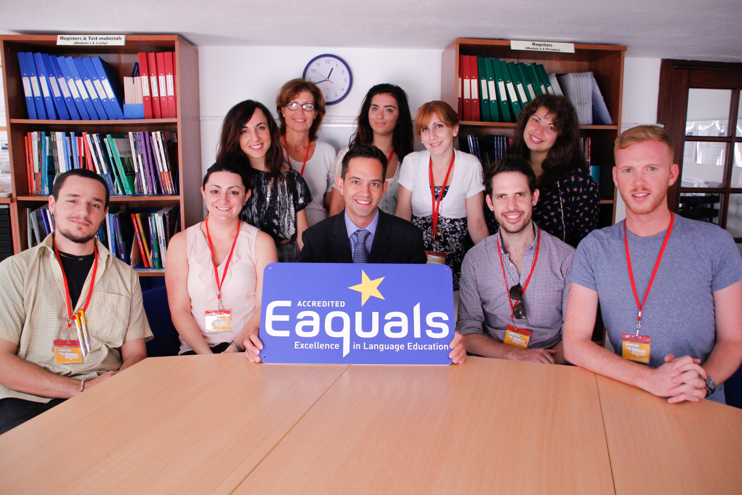 Staff team at a Malta language school holding an Eaquals accreditation sign in the office