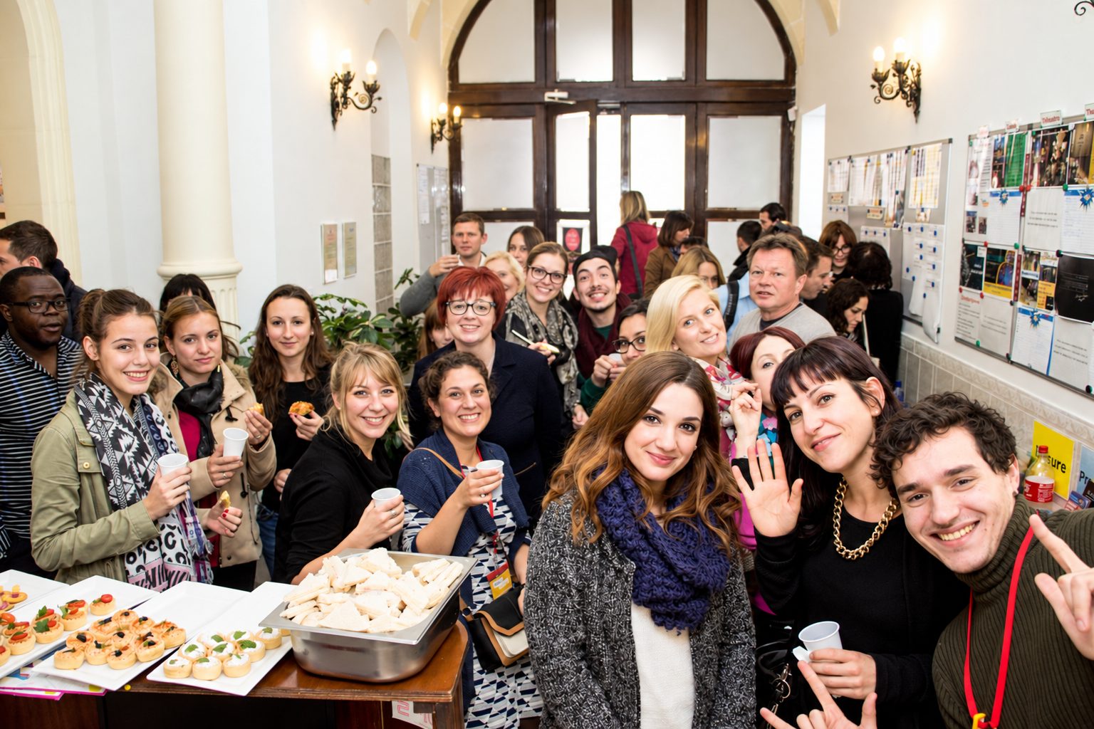 Language school students and staff gather for a welcome reception with sandwiches in a historic Malta building