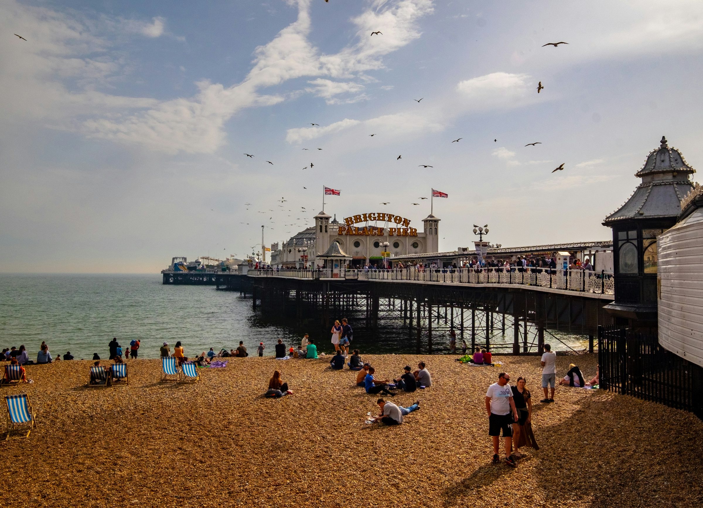 Brighton Palace Pier stretching over the sea, seen from the pebble beach on a sunny day