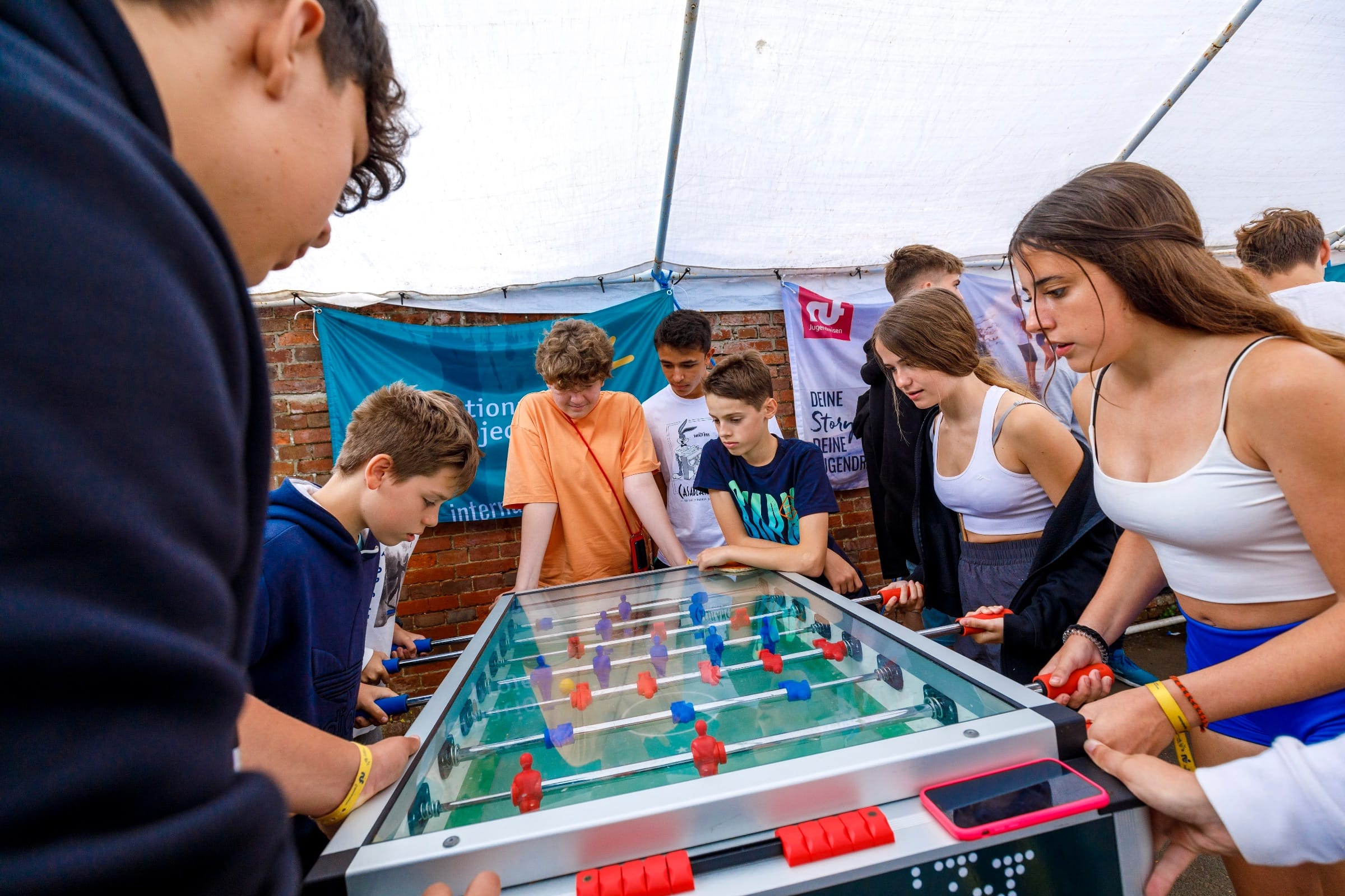 Junior students playing table football together at a Bournemouth summer camp tent