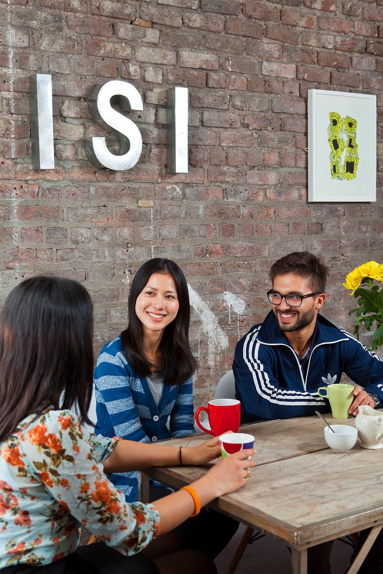 Adult students chatting over coffee beneath the ISI sign at Meetinghouse Lane school in Ireland
