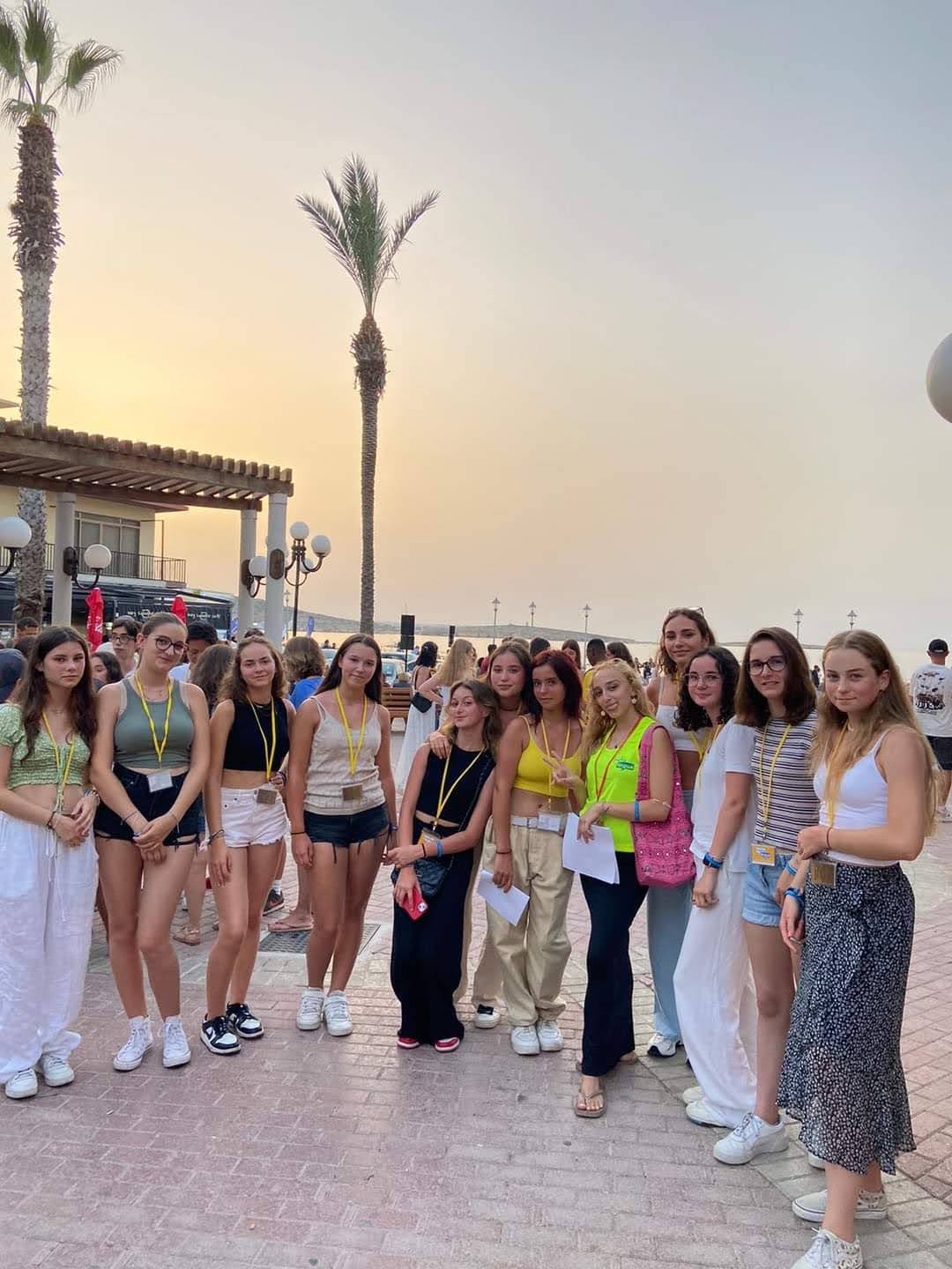 Junior students on a seaside promenade in Malta during a golden sunset evening walk