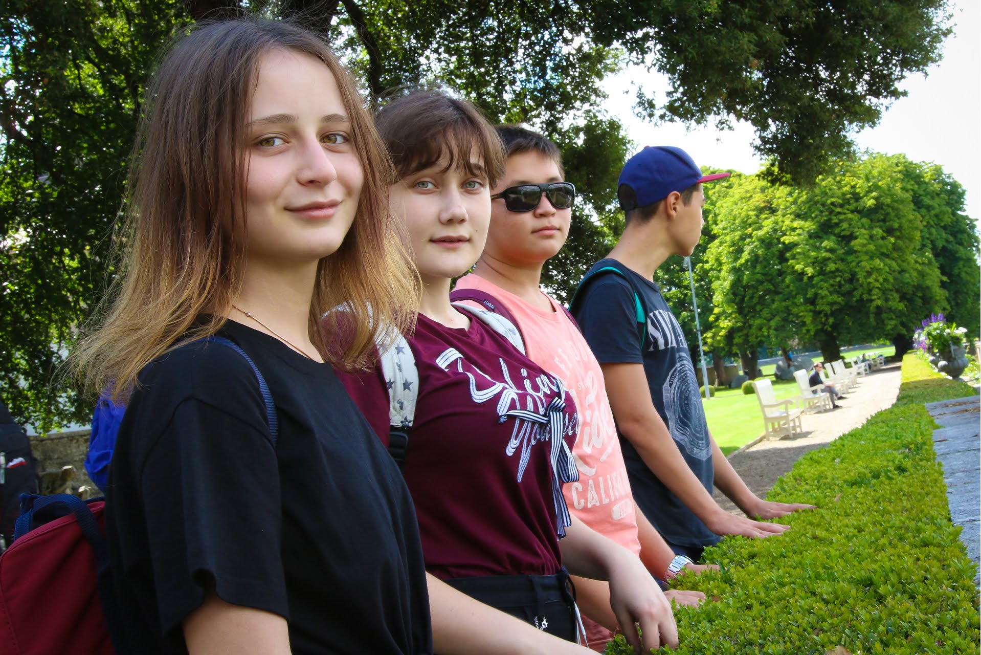 Teen students lined up along a garden hedge during a Dublin summer camp excursion