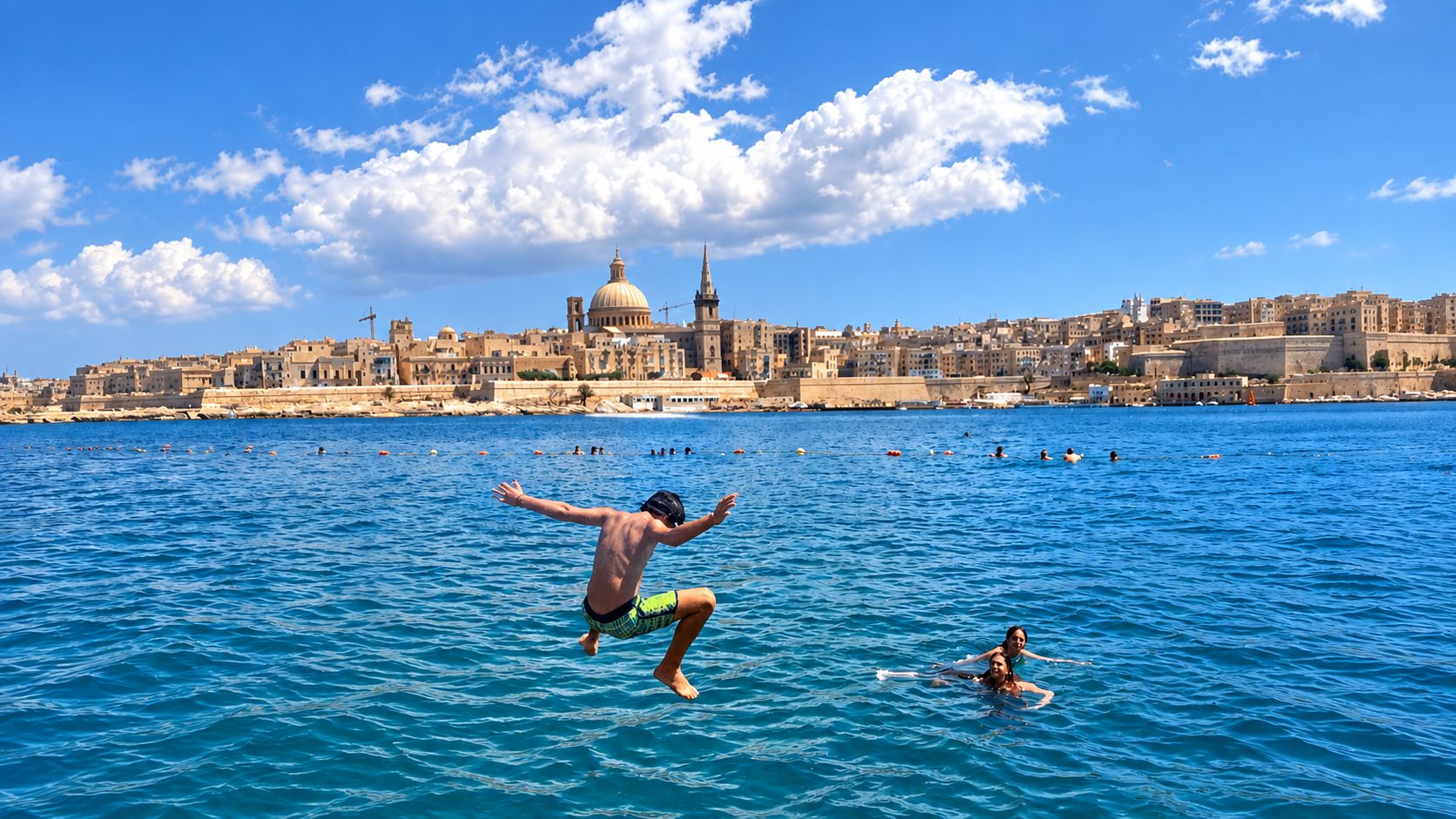 Student jumping into the sea near Valletta's skyline during a language course in Malta