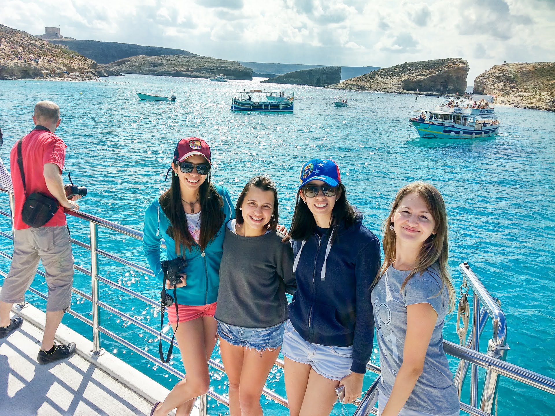 Adult students smiling on a boat trip in Malta's Blue Lagoon during a language course excursion