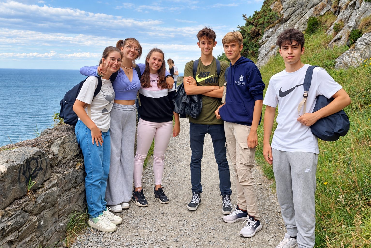 Group of teenage students posing on a coastal cliff path during a study abroad excursion