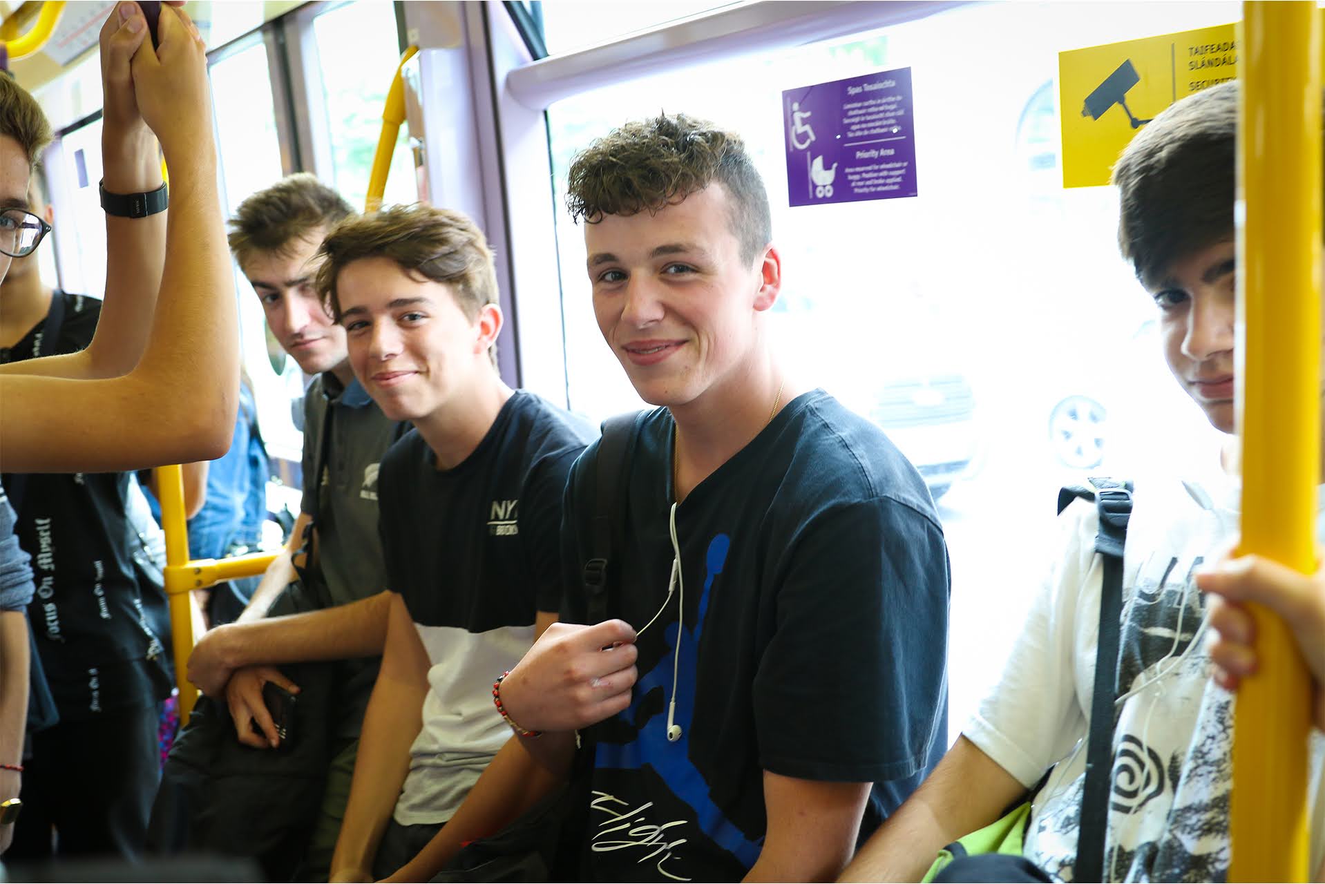 Teenage students smiling while riding public transport during an ISI Dublin junior summer camp excursion