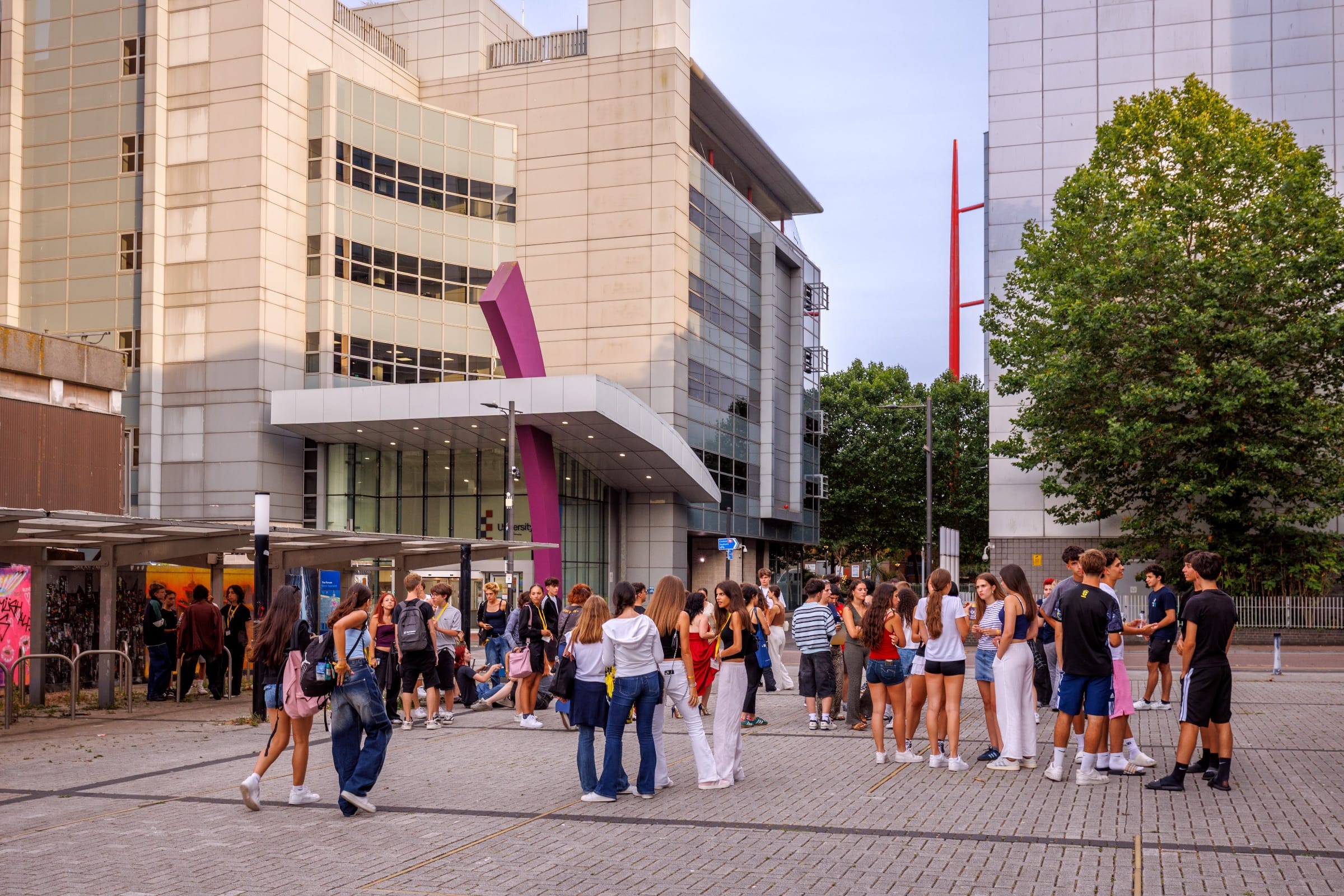 Teen students gathering outside university buildings during a summer camp excursion in Southend-on-Sea