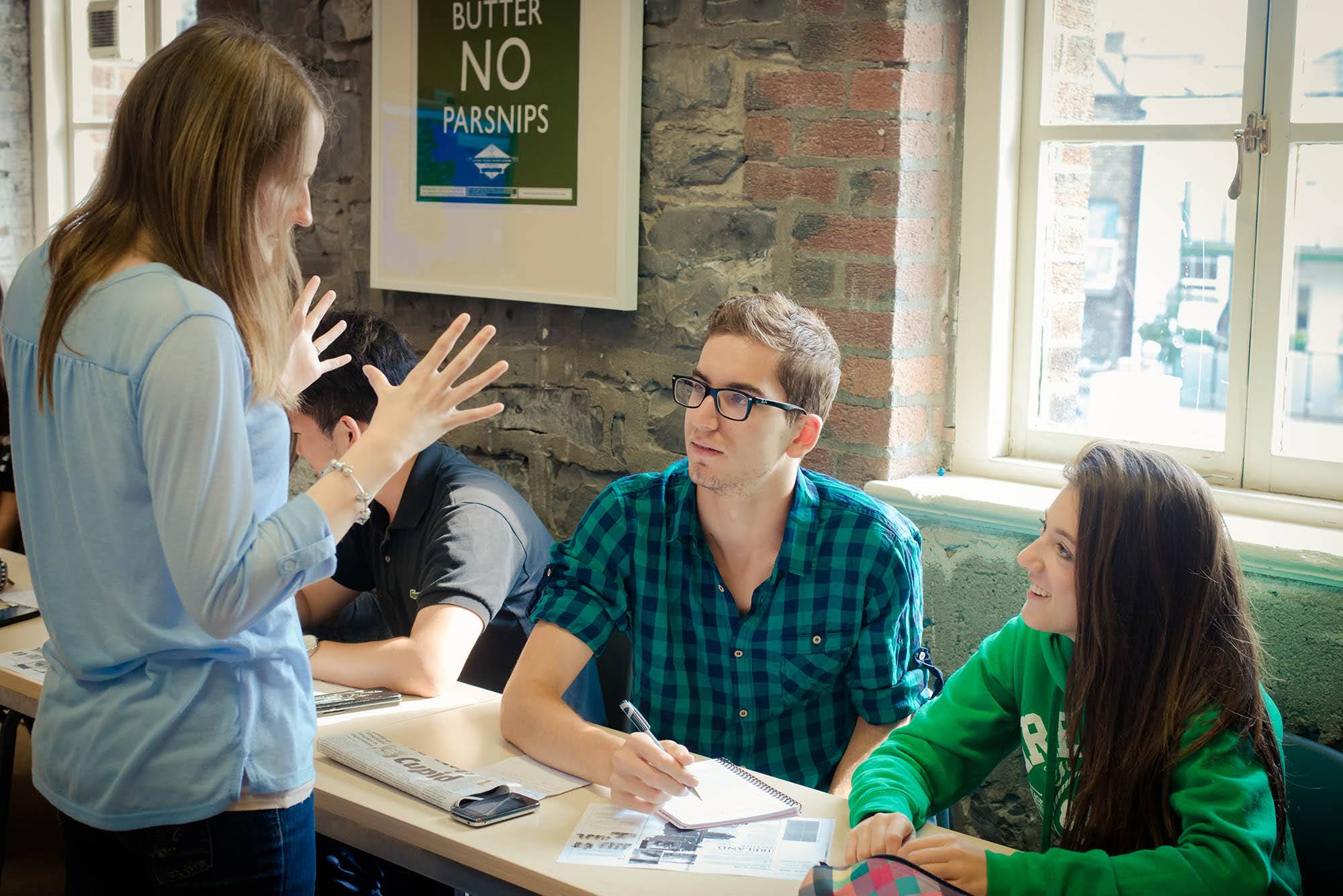 Adult students discussing an English exercise with their teacher at ISI Ireland