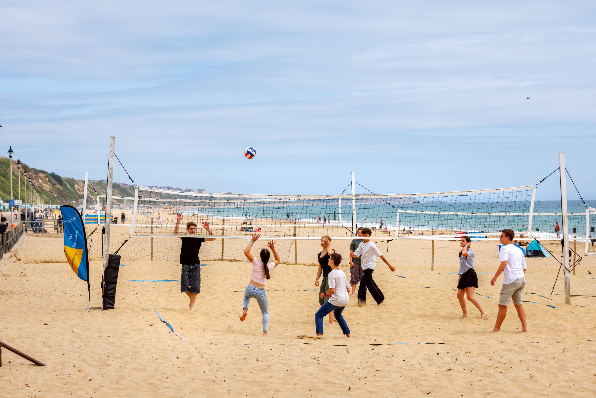 Junior summer camp students playing beach volleyball on Bournemouth beach during their IP English course